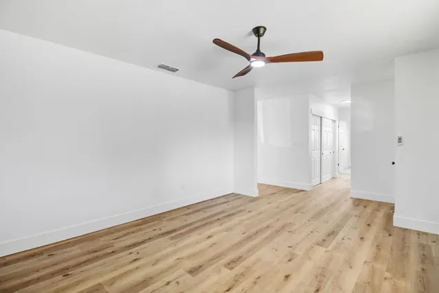 a view of empty room with wooden floor