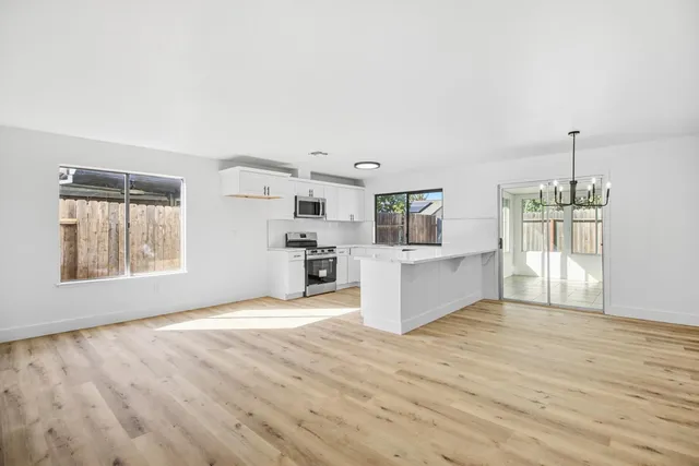 a view of a kitchen with furniture and wooden floor