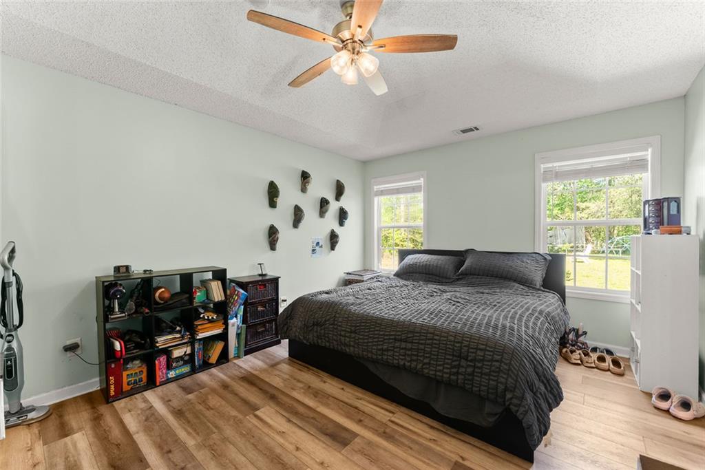 654 Marigold Lane Mount Airy, GA 30563 - Photo 15 of 27 a bedroom with a bed and a wooden floor