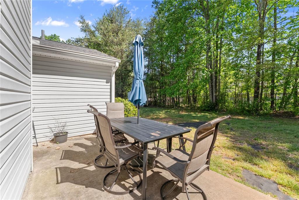 654 Marigold Lane Mount Airy, GA 30563 - Photo 26 of 27 a view of a backyard with table and chairs with wooden floor and fence