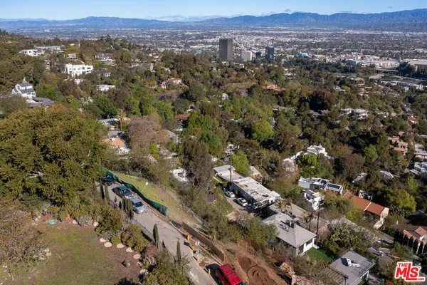 an aerial view of residential houses with outdoor space and trees