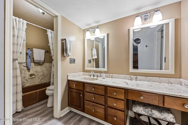 a bathroom with a granite countertop sink mirror and a shower