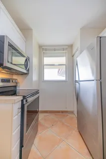 a kitchen with stainless steel appliances granite countertop a refrigerator a stove and a sink with granite countertops