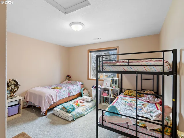 a bedroom with a bed and a wooden floor