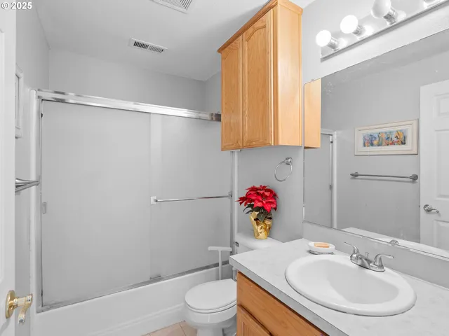 a bathroom with a sink vanity mirror and toilet