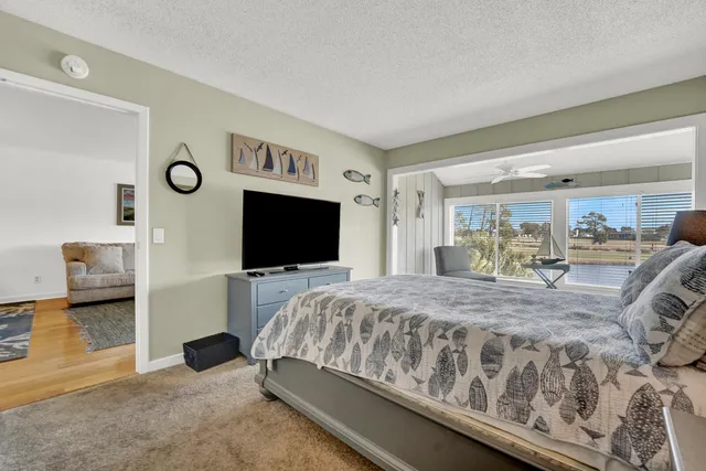a bedroom with a bed and a flat tv screen on wall
