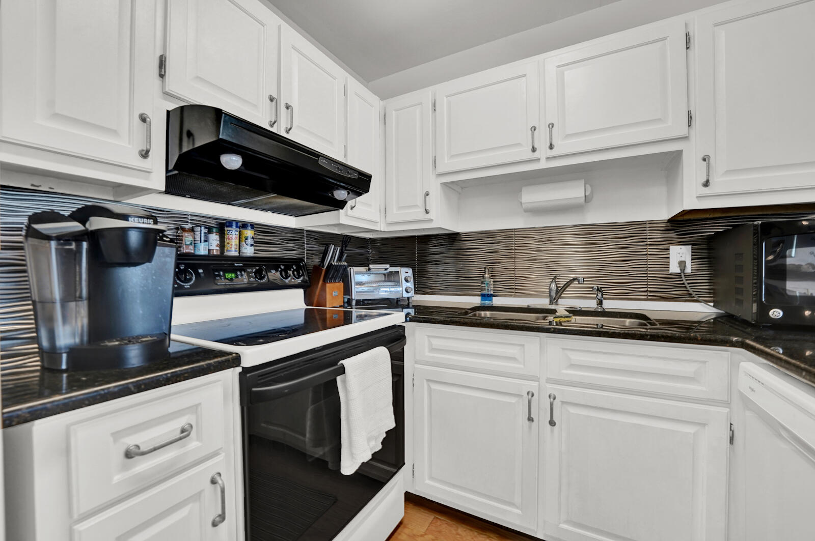 4725 Bay Point Road, Unit 261 Panama City Beach, FL 32408 - Photo 4 of 38 a kitchen with stainless steel appliances granite countertop a sink a stove and a microwave