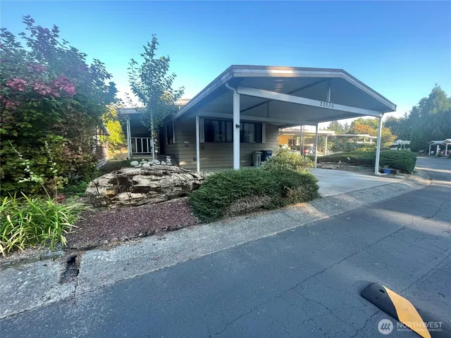 a view of a house with brick walls and a yard with plants