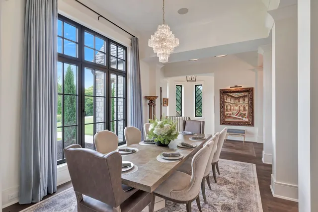 a kitchen with stainless steel appliances granite countertop a stove a refrigerator a kitchen island a table and chairs