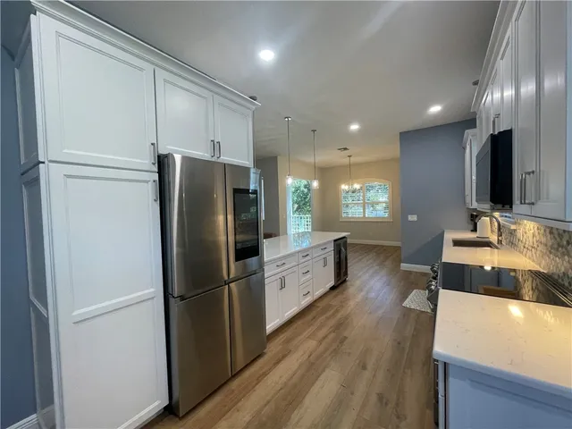 a kitchen with stainless steel appliances granite countertop a refrigerator a sink and a stove