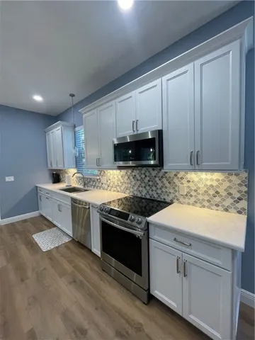 a kitchen with granite countertop white cabinets and white appliances