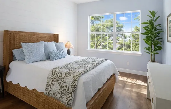 a large bed sitting in a bedroom next to a window