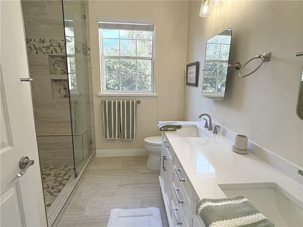 a bathroom with a sink a toilet and shower