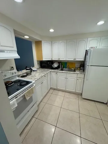 a kitchen with a sink a stove a refrigerator and cabinets