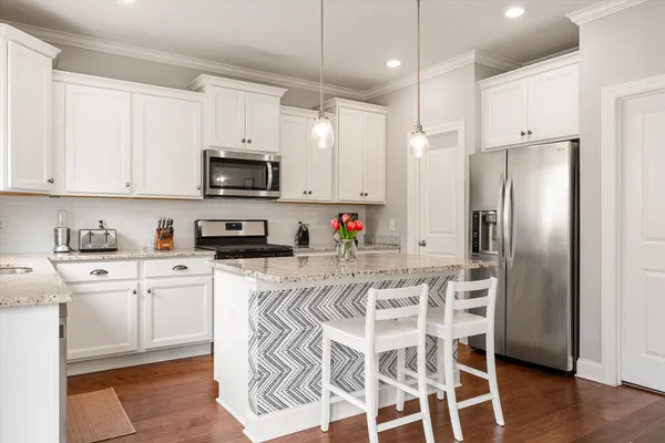 a kitchen with a refrigerator a microwave and cabinets