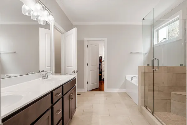 a bathroom with a tub a sink and a large mirror