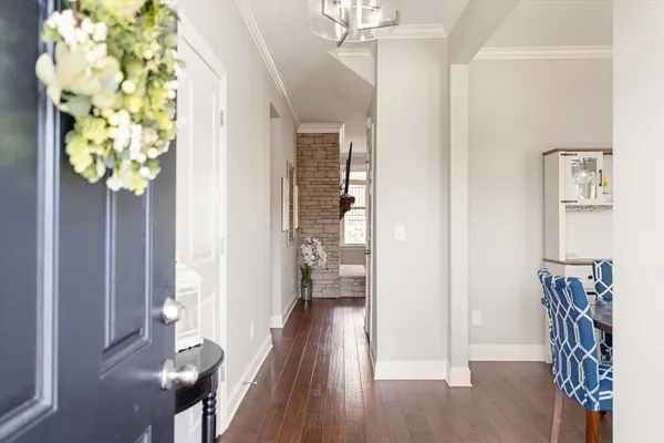 a view of hallway with chandelier and wooden floor