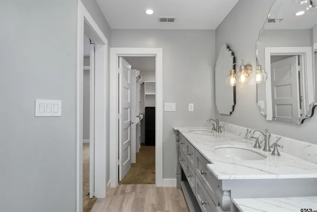 a en suite bathroom with a double vanity sink and a mirror