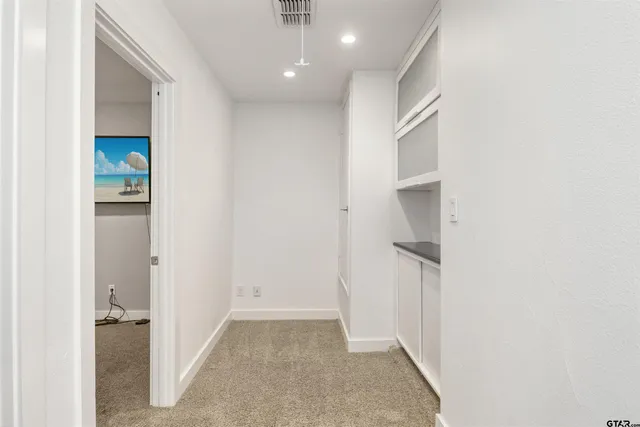 a view of a hallway with closet and a bathroom