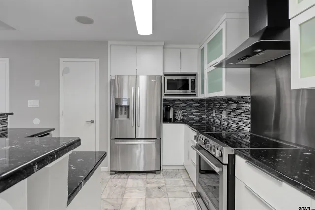 a kitchen with granite countertop a refrigerator and a sink