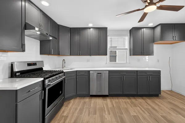 a kitchen with stainless steel appliances granite countertop a stove a sink and a refrigerator
