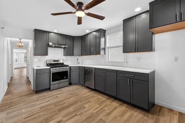 a kitchen with stainless steel appliances kitchen island granite countertop a refrigerator and a stove top oven