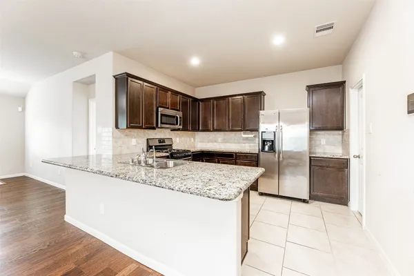 a kitchen with stainless steel appliances granite countertop a sink refrigerator and microwave