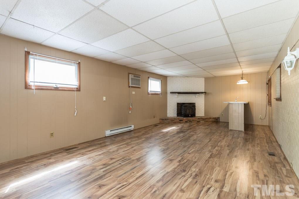 3540 Brentwood Road Raleigh, NC 27604 - Photo 14 of 29 a view of empty room with wooden floor and fireplace