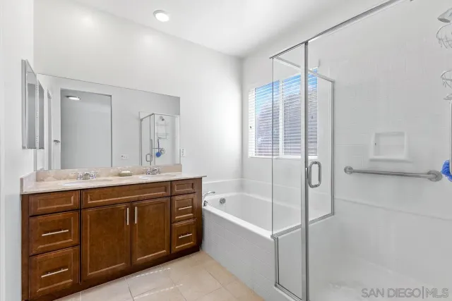 a spacious bathroom with a tub sink shower and mirror