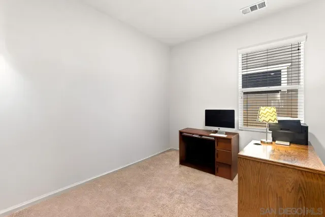 a view of a workspace with furniture and a window