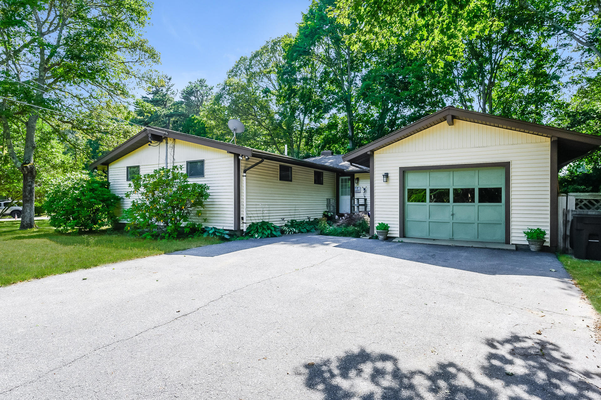 54 Pine Tree Drive Centerville, MA 02632 - Photo 2 of 16 a front view of a house with a yard and garage