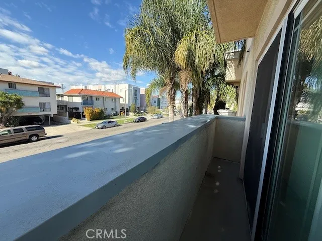 a city view with tall buildings and cars parked on road