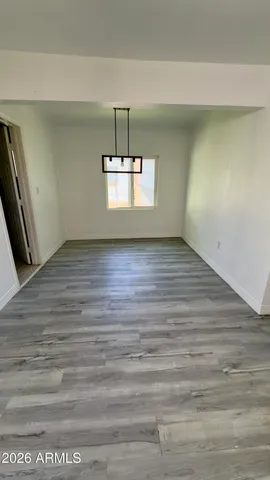 a view of a room with wooden floor staircase and a kitchen view