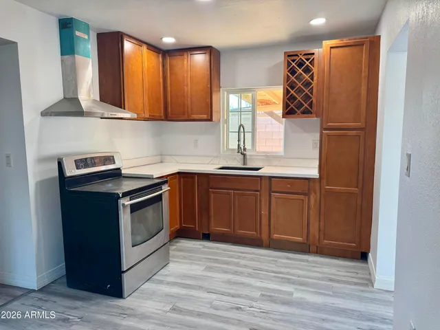 a kitchen with stainless steel appliances granite countertop a stove a sink and a refrigerator