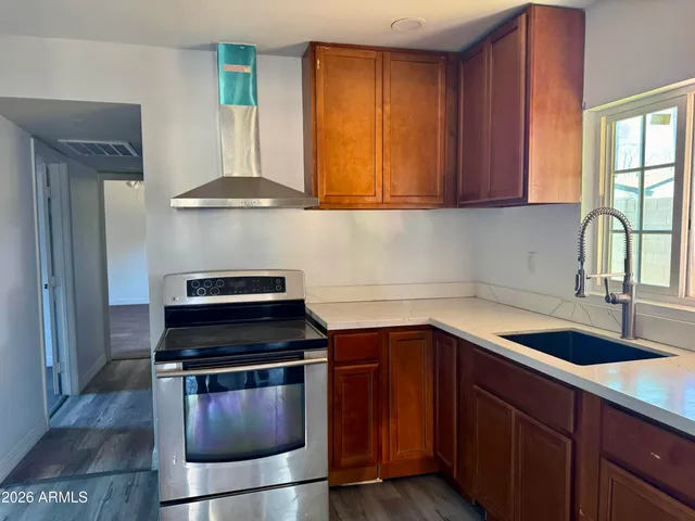 a kitchen with granite countertop a sink stove and cabinets