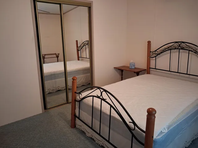 a bedroom with a bed and a mirror