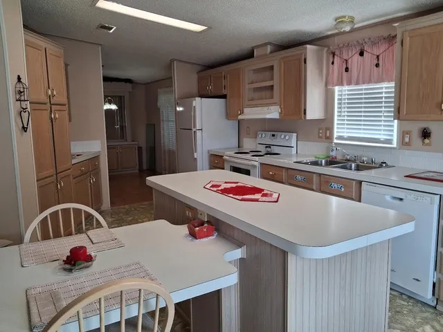 a kitchen with kitchen island a sink appliances and cabinets
