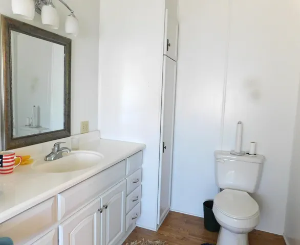 a bathroom with a granite countertop toilet sink and mirror