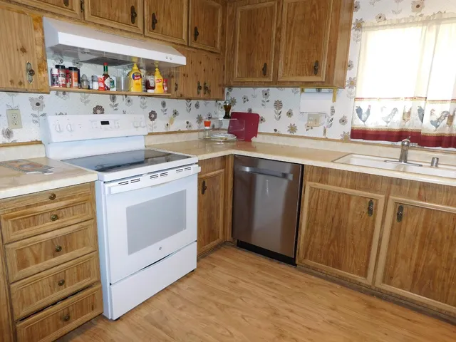 a kitchen with cabinets appliances and wooden floor