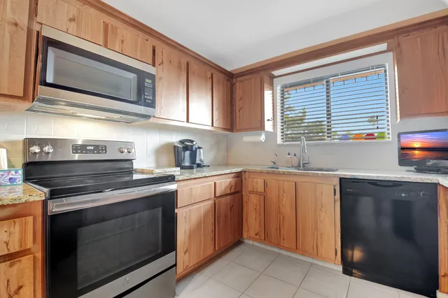a kitchen with stainless steel appliances granite countertop wooden cabinets and a stove top oven