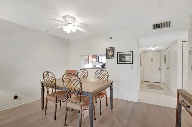 a view of a dining room with furniture and chandelier fan