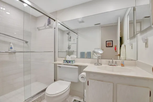 a bathroom with a sink toilet vanity and shower