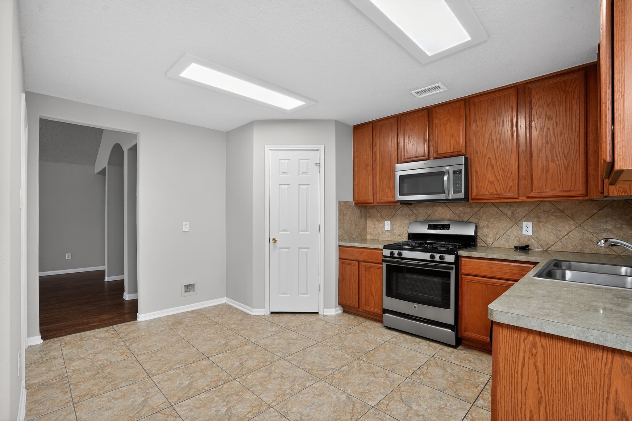 29414 Winton Wood Way Spring, TX 77386 - Photo 5 of 35 a kitchen with stainless steel appliances granite countertop a stove top oven a sink dishwasher and a refrigerator with wooden cabinets