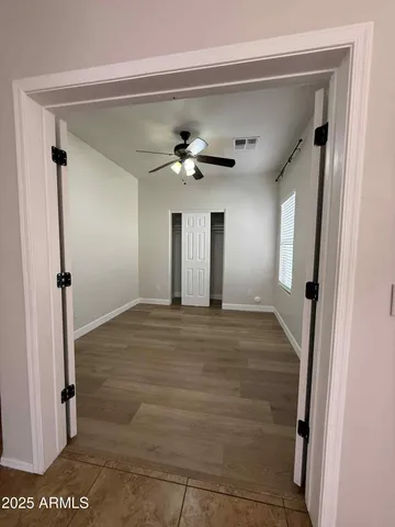 a view of a hallway with a ceiling fan