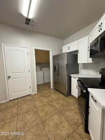 a kitchen with stainless steel appliances granite countertop a refrigerator and a stove top oven