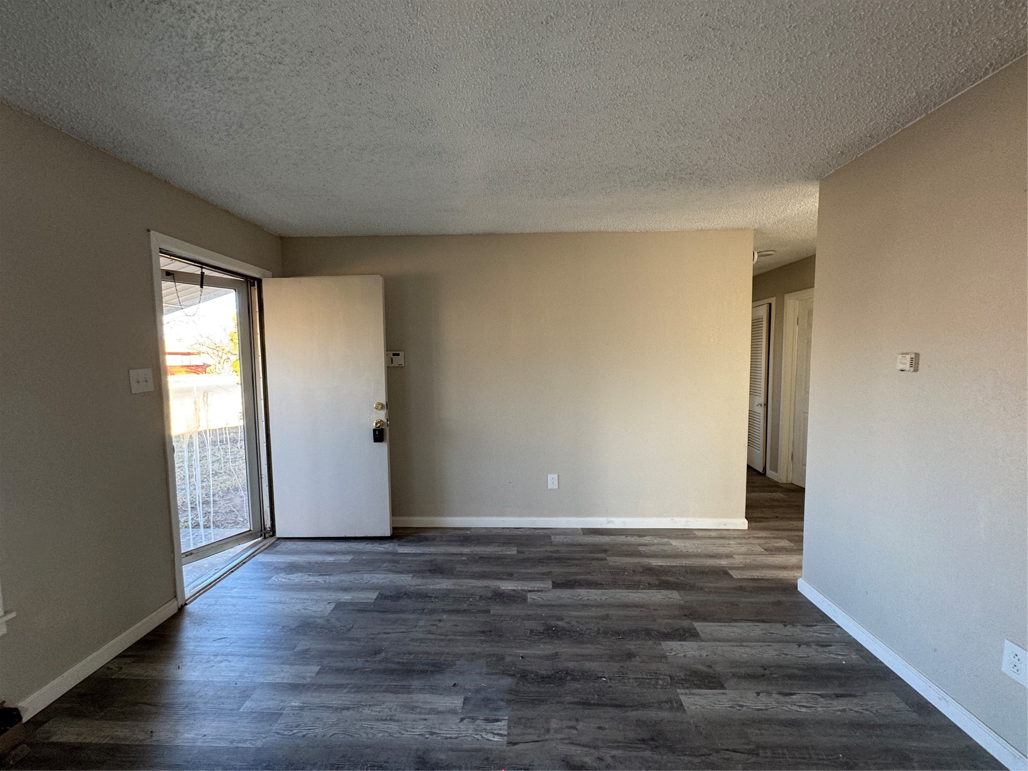 2704 East Colgate Street Lubbock, TX 79403 - Photo 3 of 11 an empty room with wooden floor and windows