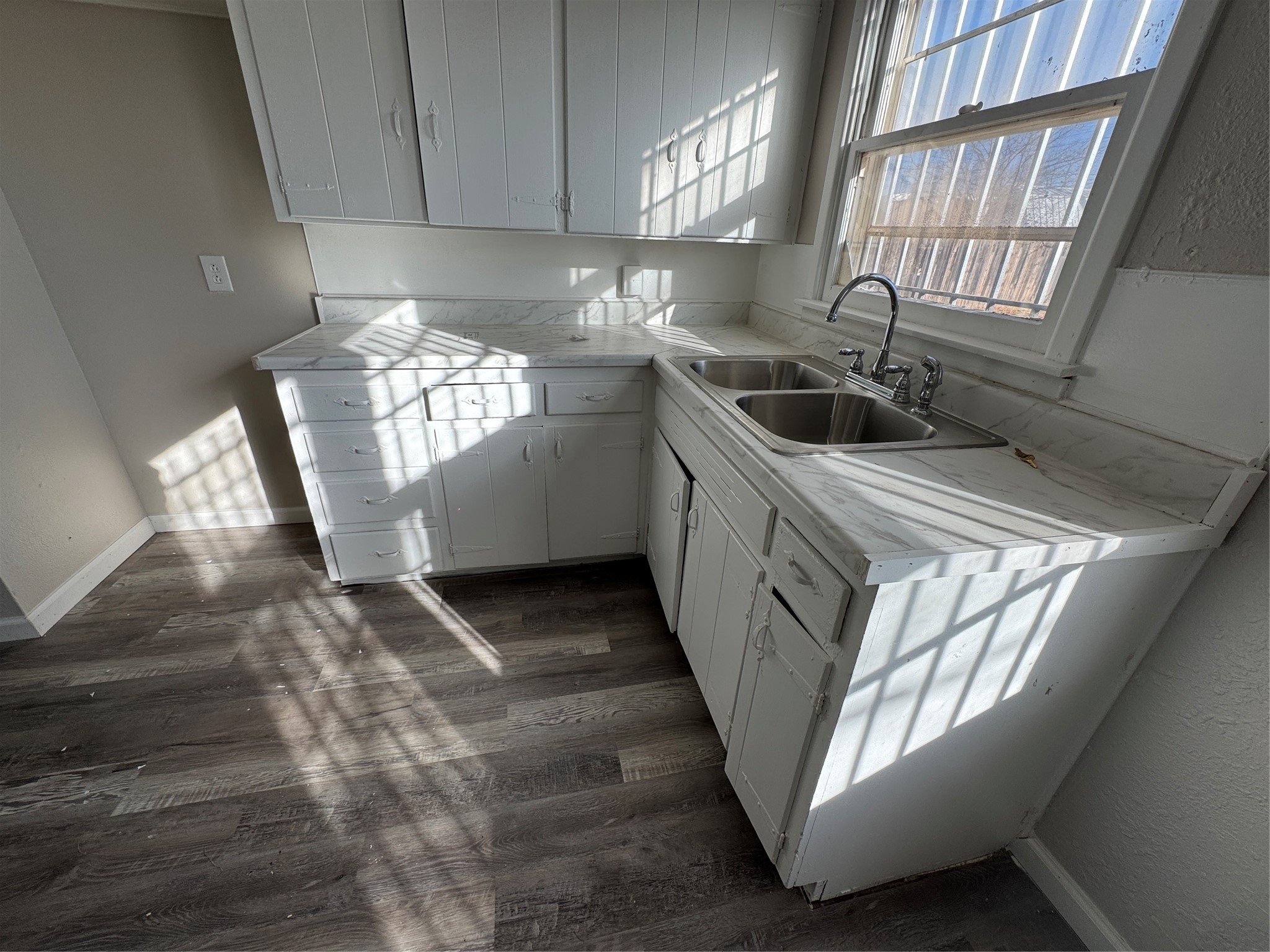 2704 East Colgate Street Lubbock, TX 79403 - Photo 6 of 11 a kitchen with windows and white cabinets