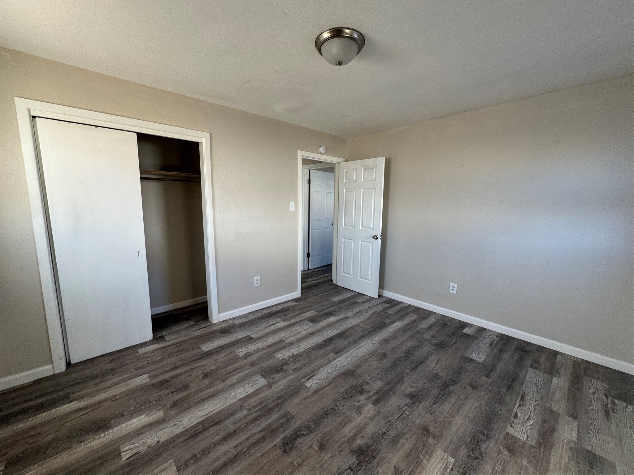 2704 East Colgate Street Lubbock, TX 79403 - Photo 9 of 11 a view of an empty room with wooden floor and closet