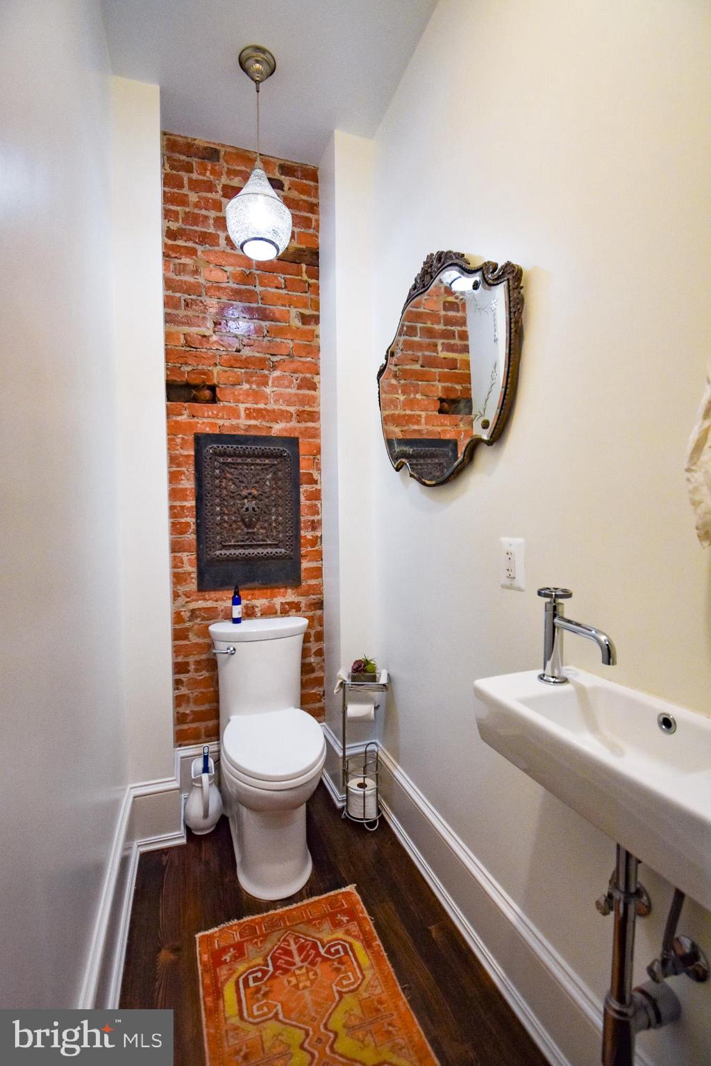1830 Columbia Road Northwest Washington, DC 20009 - Photo 11 of 46 a bathroom with a toilet a sink and a mirror