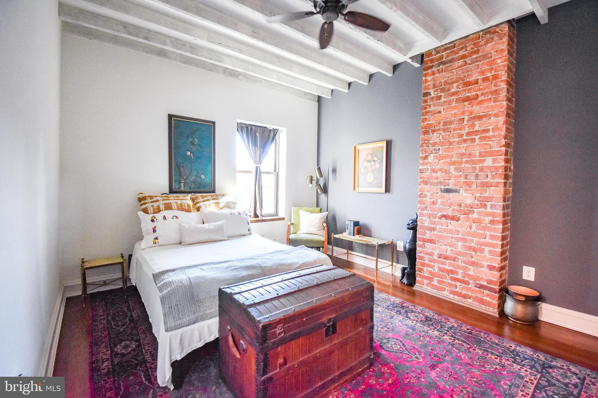 1830 Columbia Road Northwest Washington, DC 20009 - Photo 28 of 46 a bedroom with a bed and a chandelier